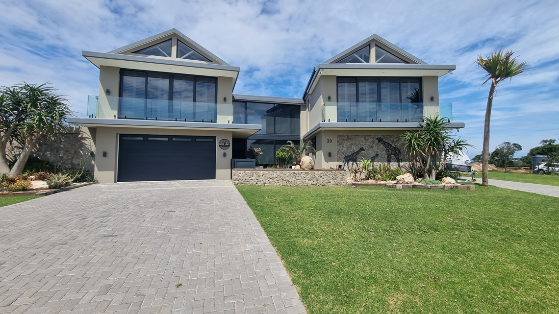 Completed luxury double-story estate by Prism Construction, premier home builders in Port Elizabeth, featuring a double garage and modern glass stacker doors at Kragga Kamma Game Park.